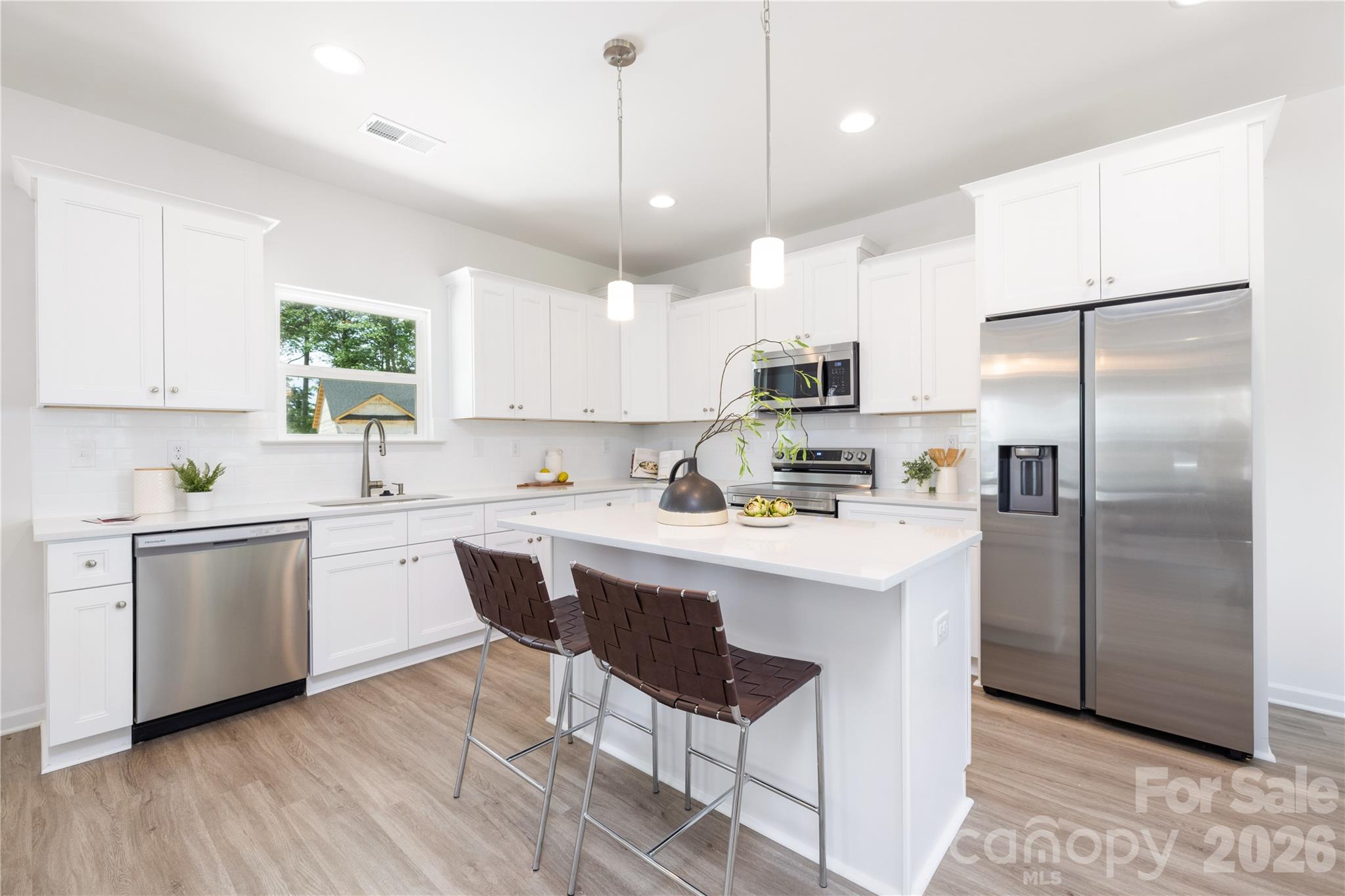 5514 Anderson Road Charlotte, NC 28269 - Photo 17 of 20 a kitchen with kitchen island a white counter space cabinets and a refrigerator