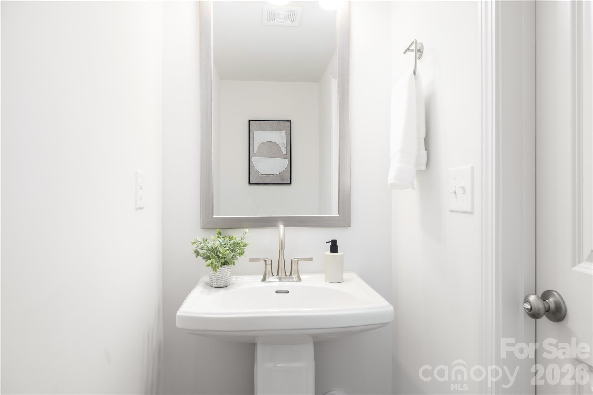 5514 Anderson Road Charlotte, NC 28269 - Photo 2 of 20 a bathroom with a sink a mirror and a toilet