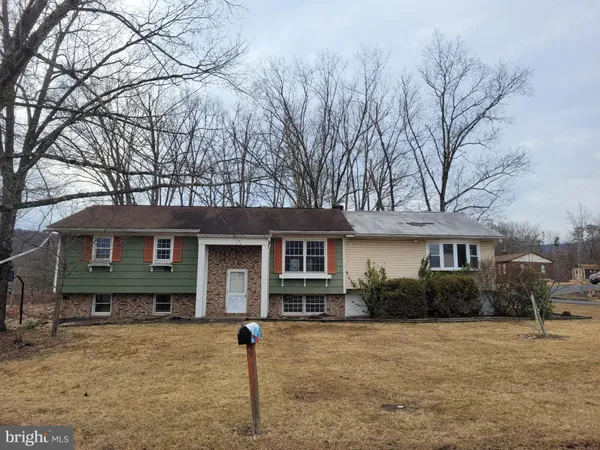 a front view of house with yard and trees around