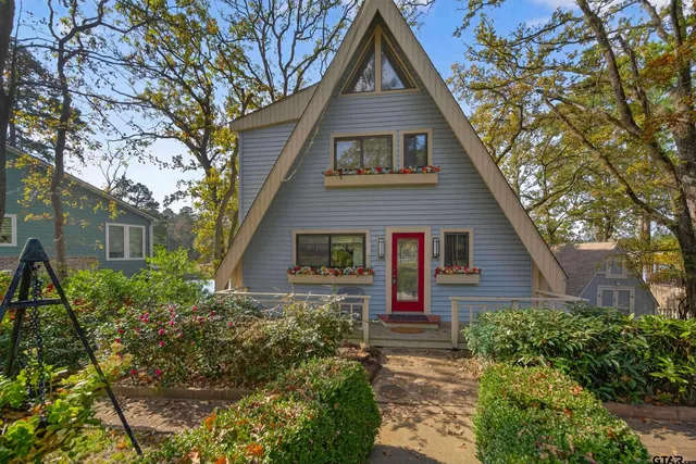 a front view of house with yard and trees around