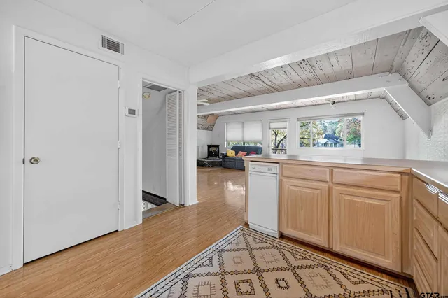 a kitchen with white cabinets and window