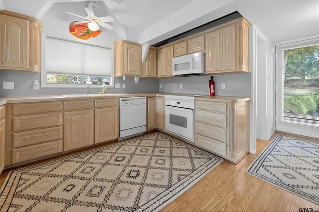 a kitchen with stainless steel appliances granite countertop a sink and cabinets