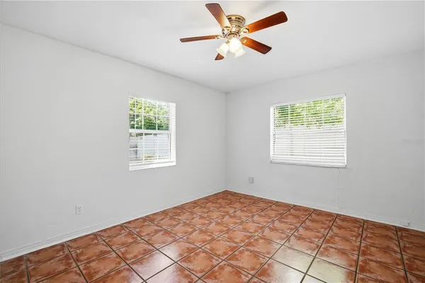 a view of a big room with wooden floor and a chandelier fan