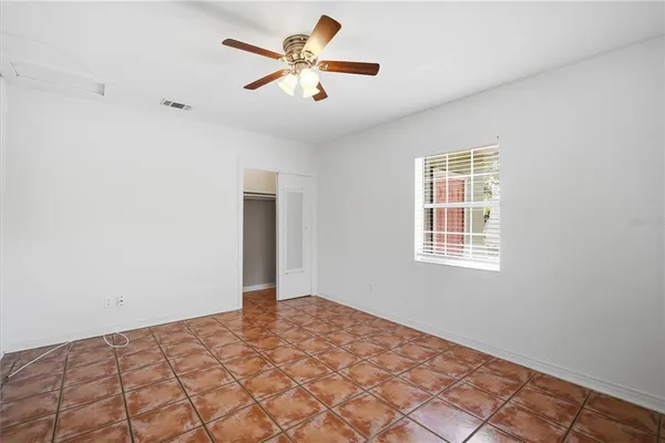 a view of a big room with wooden floor and a chandelier fan
