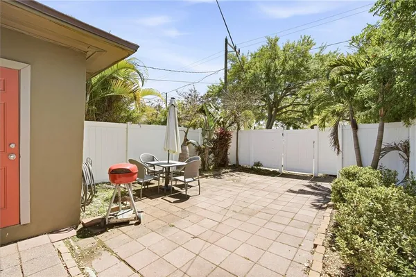 a view of a backyard with table and chairs and a large tree