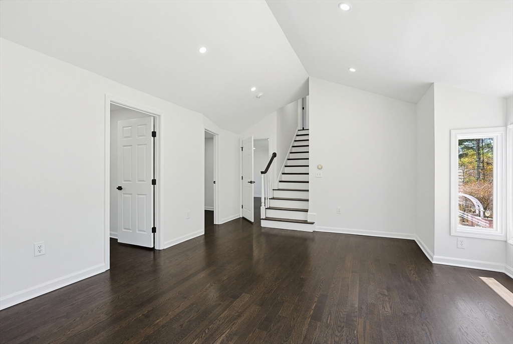 175 Pleasant Street Upton, MA 01568 - Photo 29 of 39 a view of an empty room with wooden floor and stairs