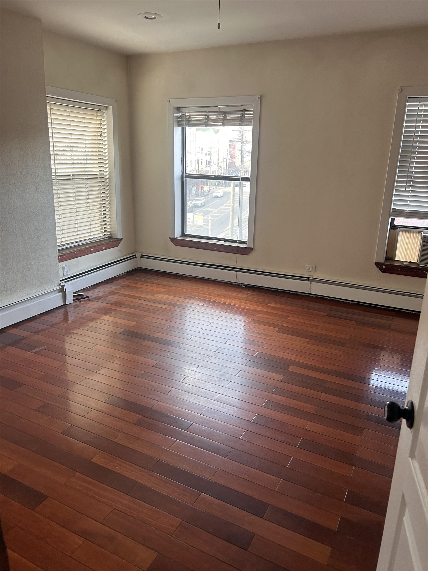 236 Grove Street Jersey City, NJ 07302 - Photo 6 of 7 an empty room with wooden floor and windows