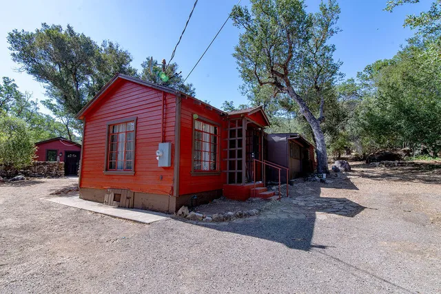 a backyard of a house with barbeque oven table and chairs