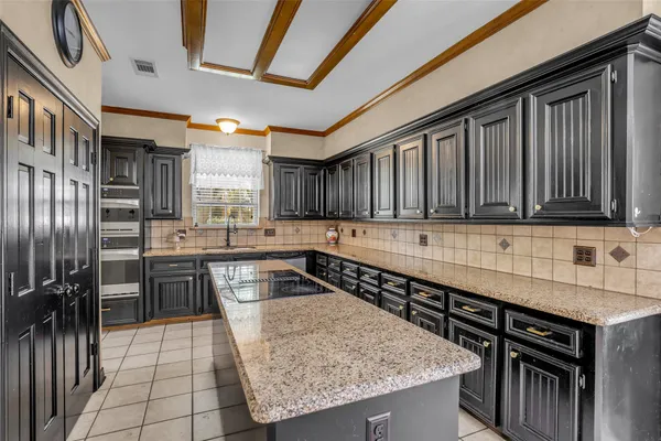 a kitchen with granite countertop a sink stainless steel appliances and cabinets