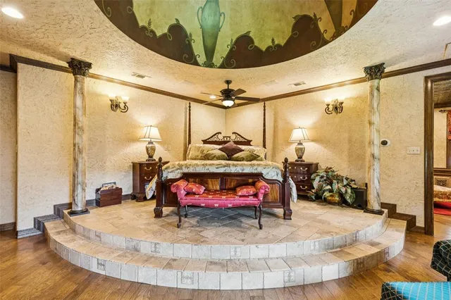 a spacious bedroom with a bed a chandelier and couch