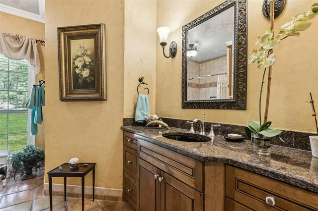 a bathroom with a granite countertop sink and a mirror