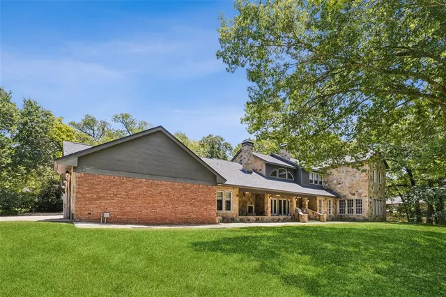 an aerial view of a house with a yard and lake view