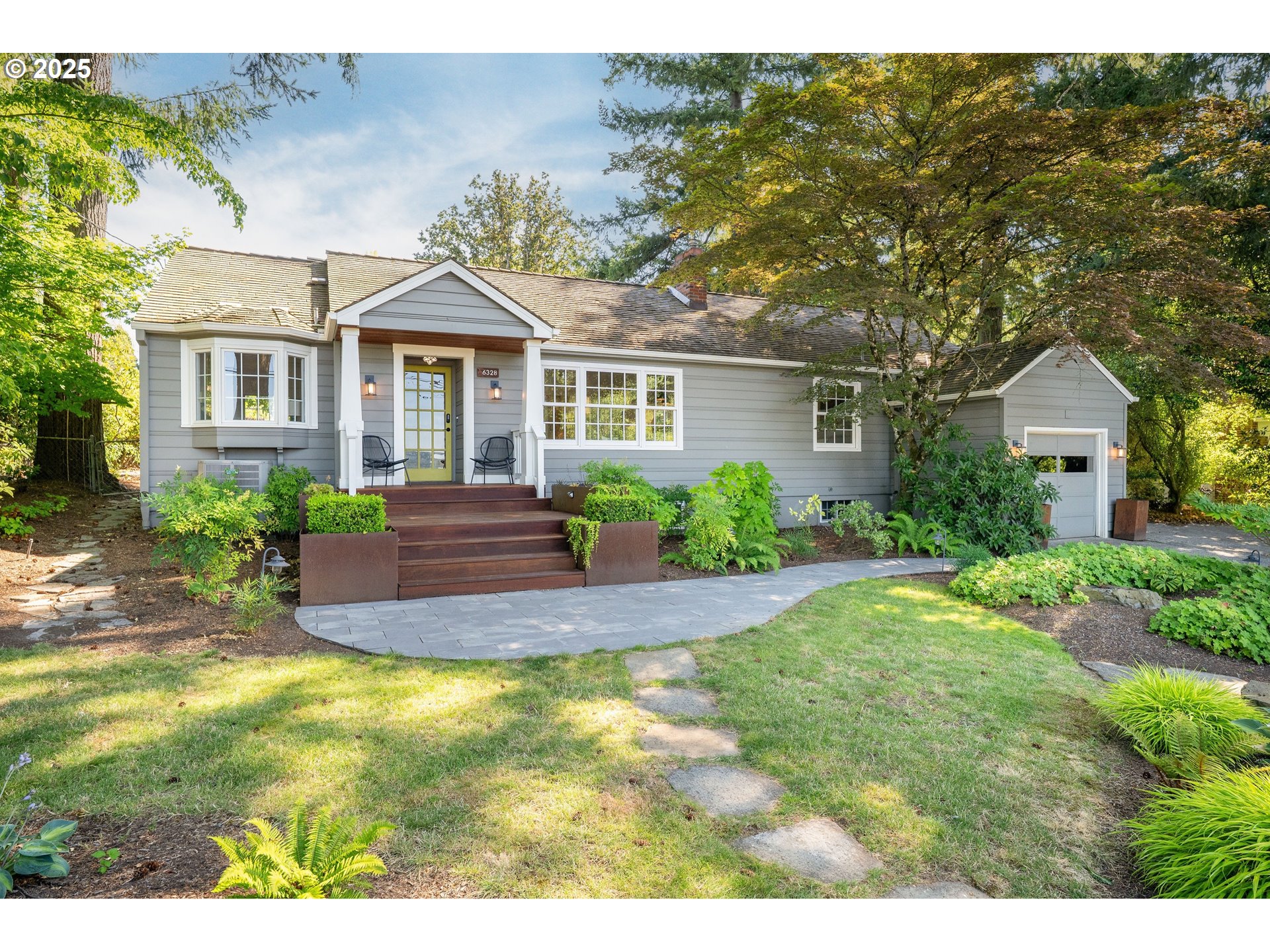 a front view of a house with a yard and potted plants