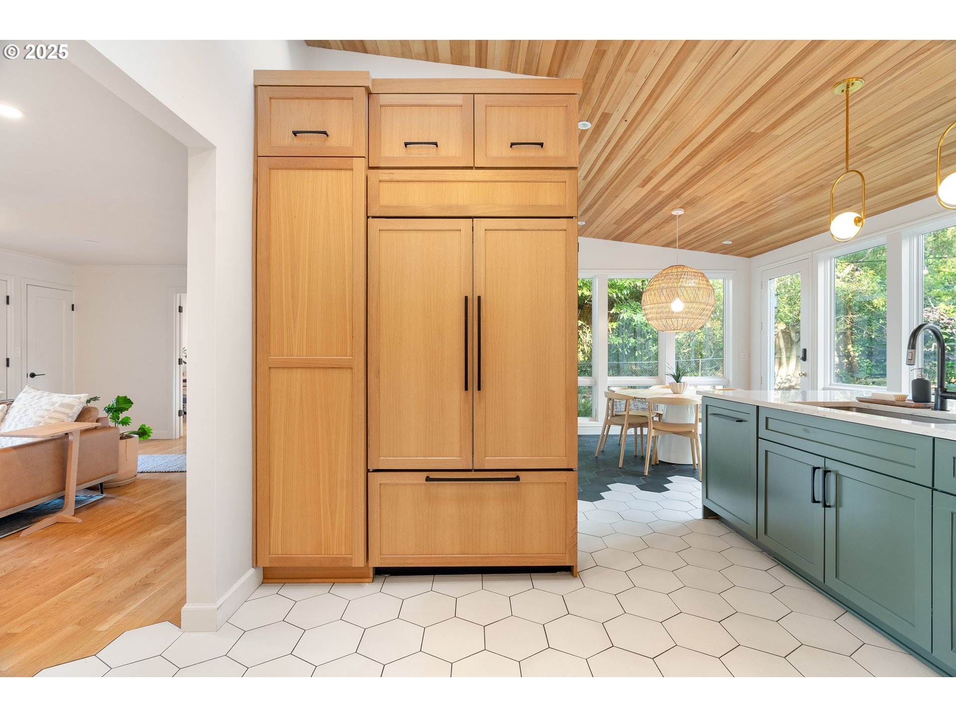 6328 Southwest Brugger Street Portland, OR 97219 - Photo 15 of 48 a kitchen with a refrigerator a stove top oven cabinetry a sink and a dining table
