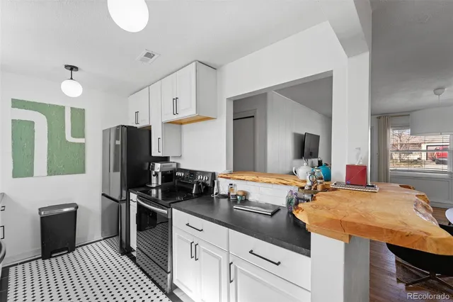a kitchen with stainless steel appliances kitchen island granite countertop a sink stove and refrigerator