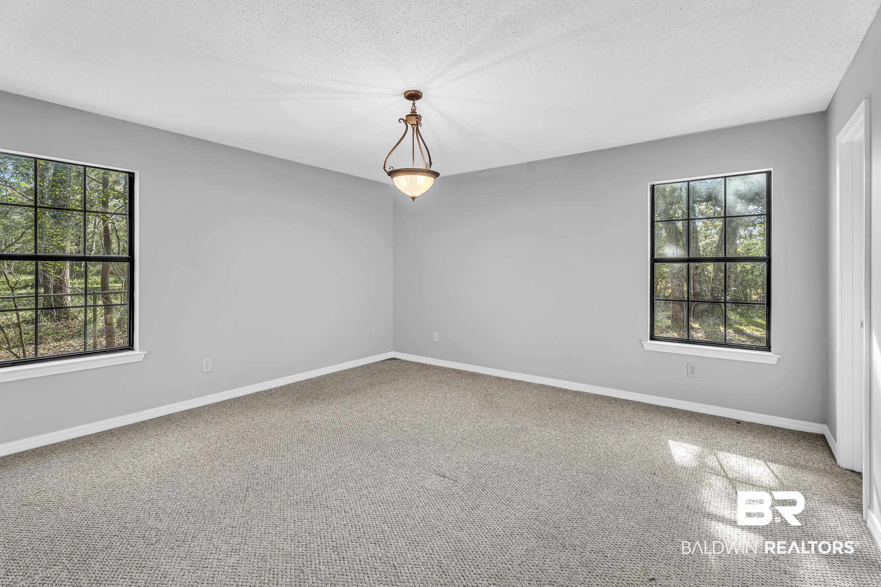 7787 Bellingrath Road Theodore, AL 36582 - Photo 22 of 36 Spare room with light colored carpet, a textured ceiling, and plenty of natural light