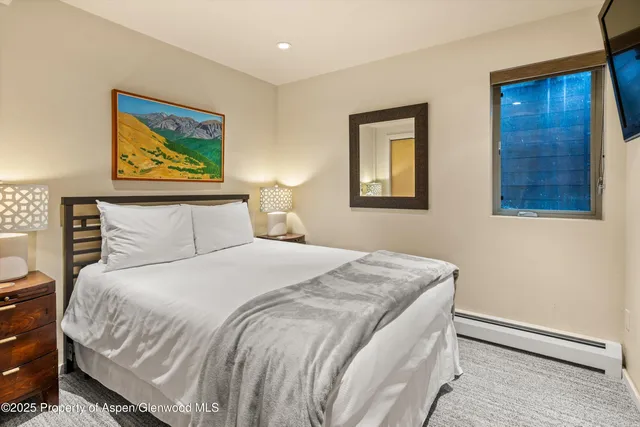 a bedroom with a bed and a painting on the wall