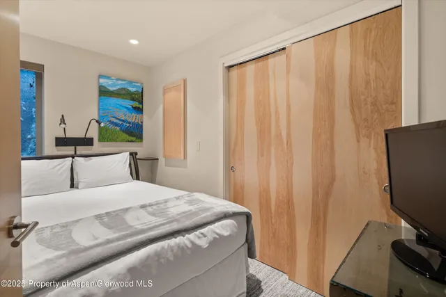 a bedroom with a bed and a flat screen tv