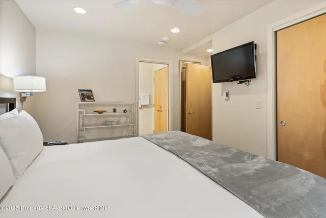 a bedroom with a bed and a flat screen tv