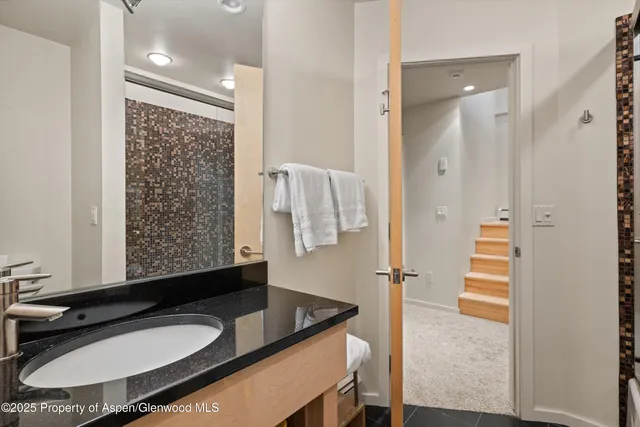 a bathroom with a granite countertop sink and a mirror
