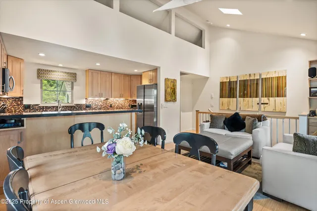 a kitchen with stainless steel appliances kitchen island granite countertop a table and chairs in it