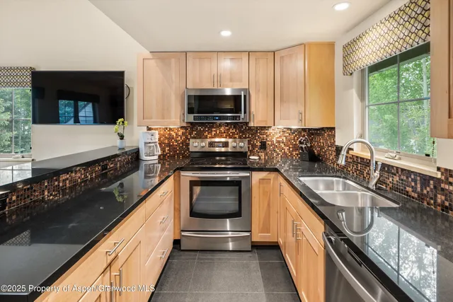 a kitchen with granite countertop a stove and a sink