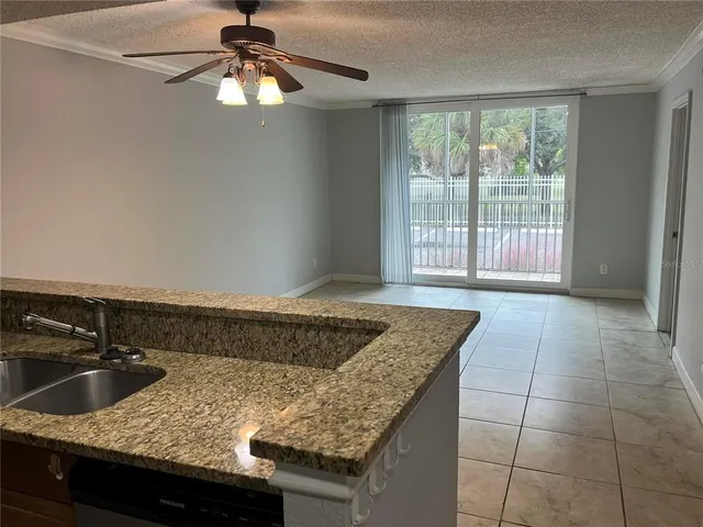 a kitchen with granite countertop a sink a counter top space and cabinets
