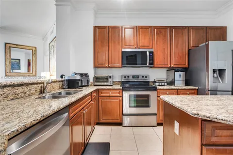a kitchen with granite countertop stainless steel appliances a stove sink and microwave