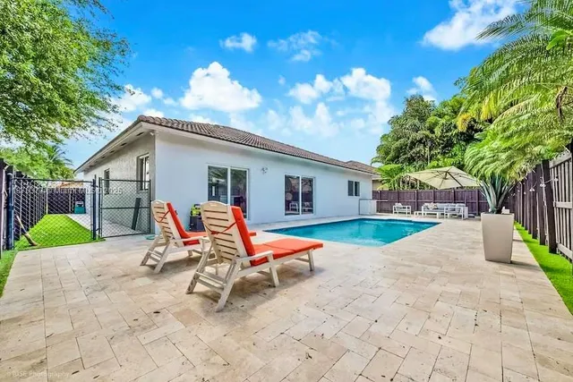 a view of a chair and table in backyard of the house