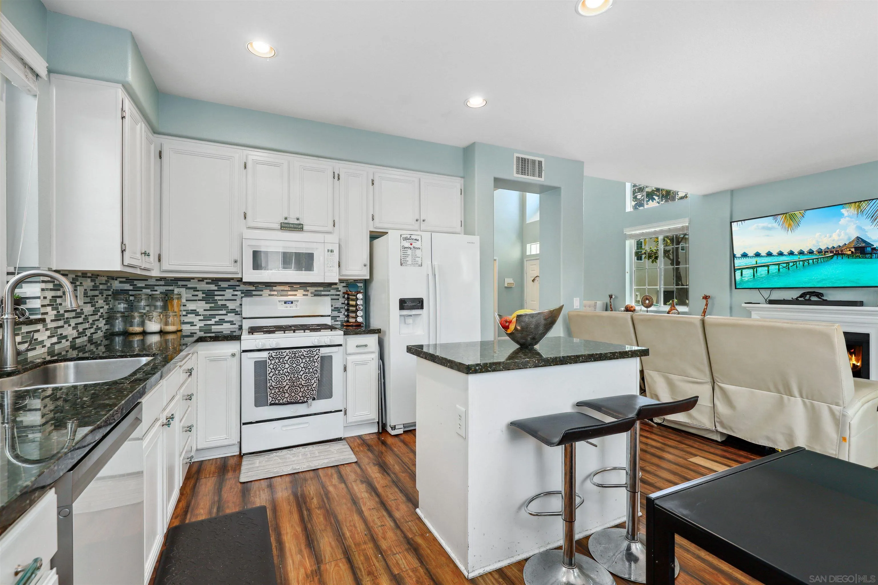 535 Venetia Way Oceanside, CA 92057 - Photo 5 of 27 a kitchen with white cabinets and stainless steel appliances