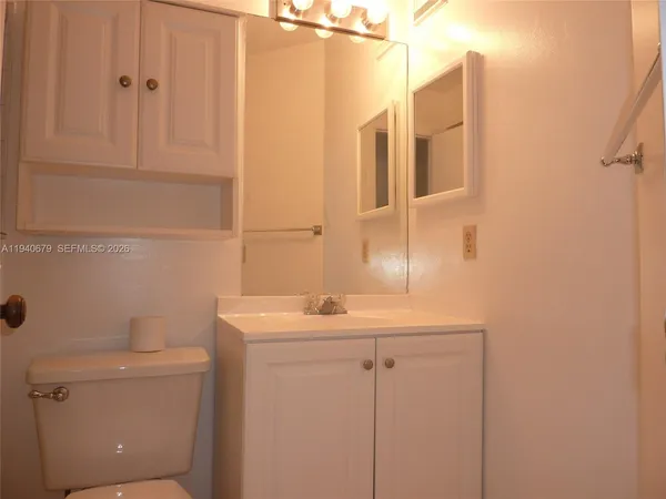 a bathroom with a sink a toilet and mirror