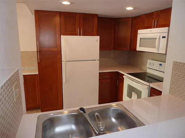 a kitchen with a refrigerator and a sink