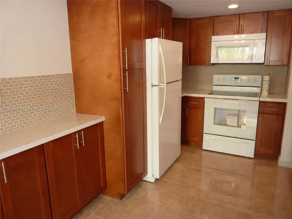 a kitchen with a refrigerator sink and cabinets