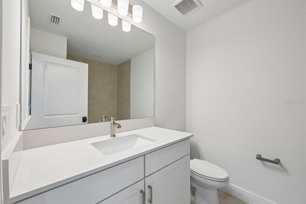 17712 Broadleaf Loop Venice, FL 34293 - Photo 14 of 23 a bathroom with a sink a toilet and a mirror