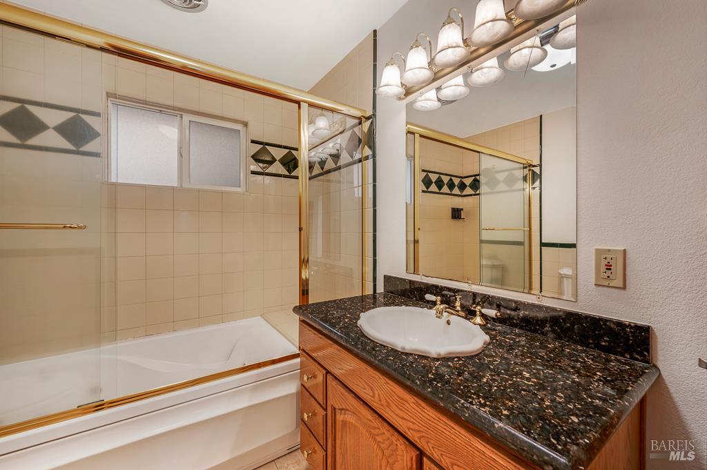 815 Dry Creek Road Healdsburg, CA 95448 - Photo 19 of 37 a bathroom with a granite countertop sink a mirror and a shower