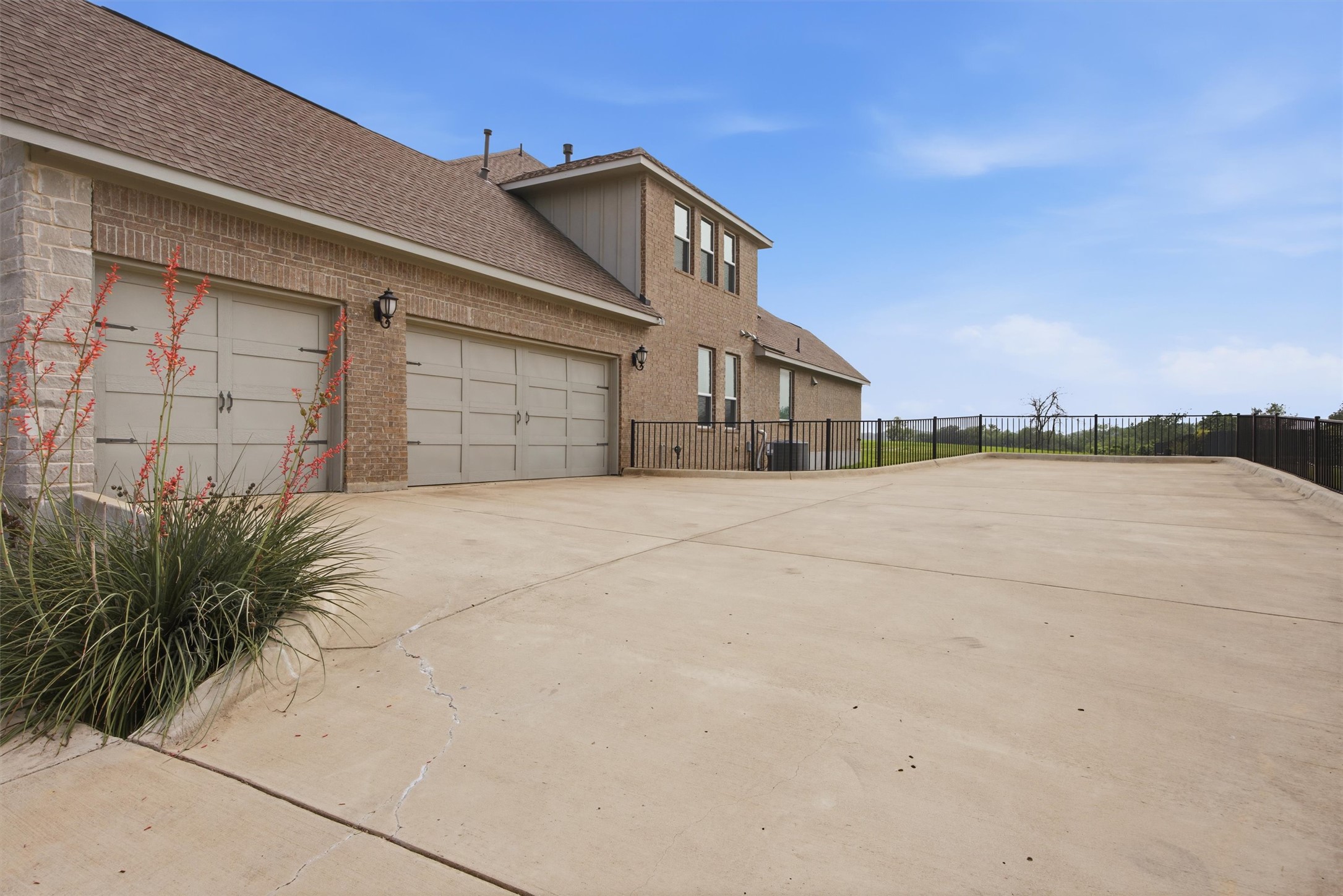 192 Raptor Beak Way Cedar Creek, TX 78612 - Photo 35 of 38 Two-story brick exterior featuring a three-car garage with carriage-style doors