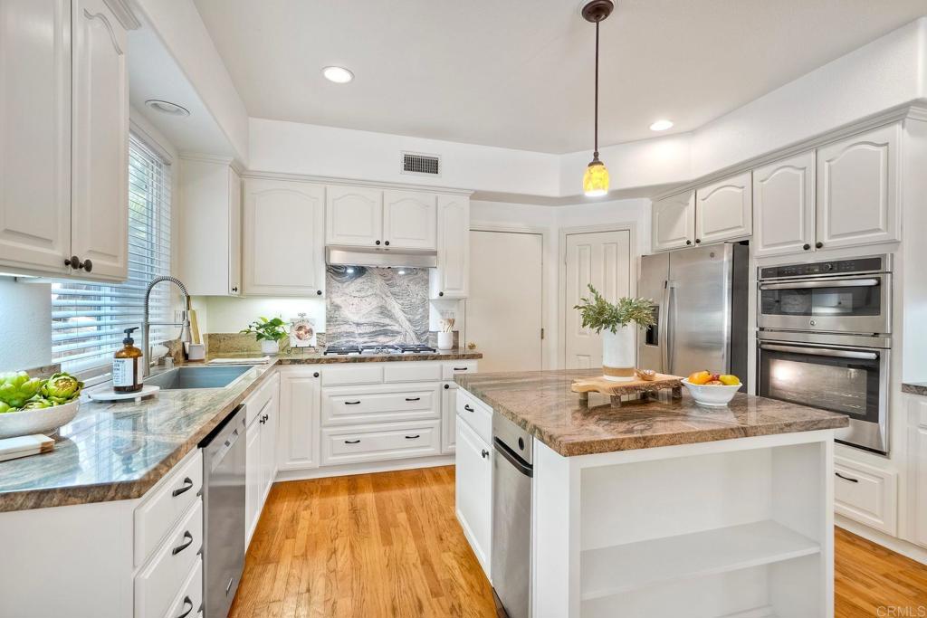 1026 Turnstone Road Carlsbad, CA 92011 - Photo 5 of 38 a kitchen with kitchen island granite countertop stainless steel appliances a sink stove and refrigerator