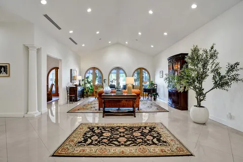 a living room with furniture a chandelier and a dining table