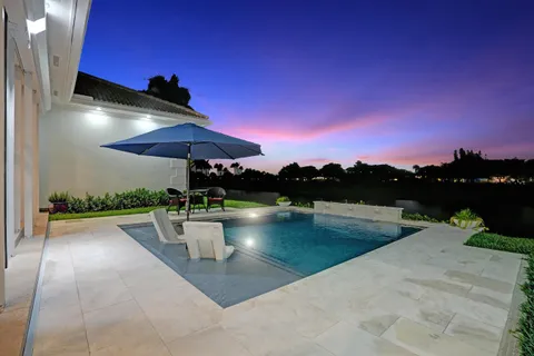 a view of a swimming pool with outdoor seating and a lake