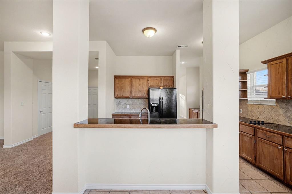 208 Cobblestone Circle Red Oak, TX 75154 - Photo 18 of 38 a kitchen with kitchen island granite countertop a sink and refrigerator