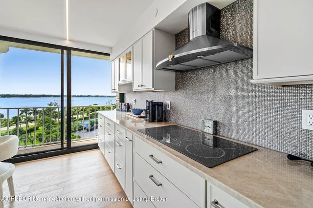 a kitchen with stainless steel appliances granite countertop a sink a stove and a wooden floors