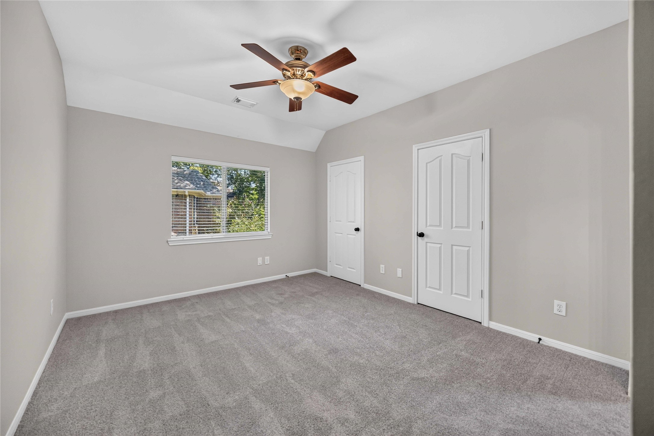 3303 Raleigh Row Missouri City, TX 77459 - Photo 34 of 50 Secondary bedroom featuring 2 Closets, soft carpeting, neutral walls, and ample natural light from a large window, complete with a ceiling fan for comfort.