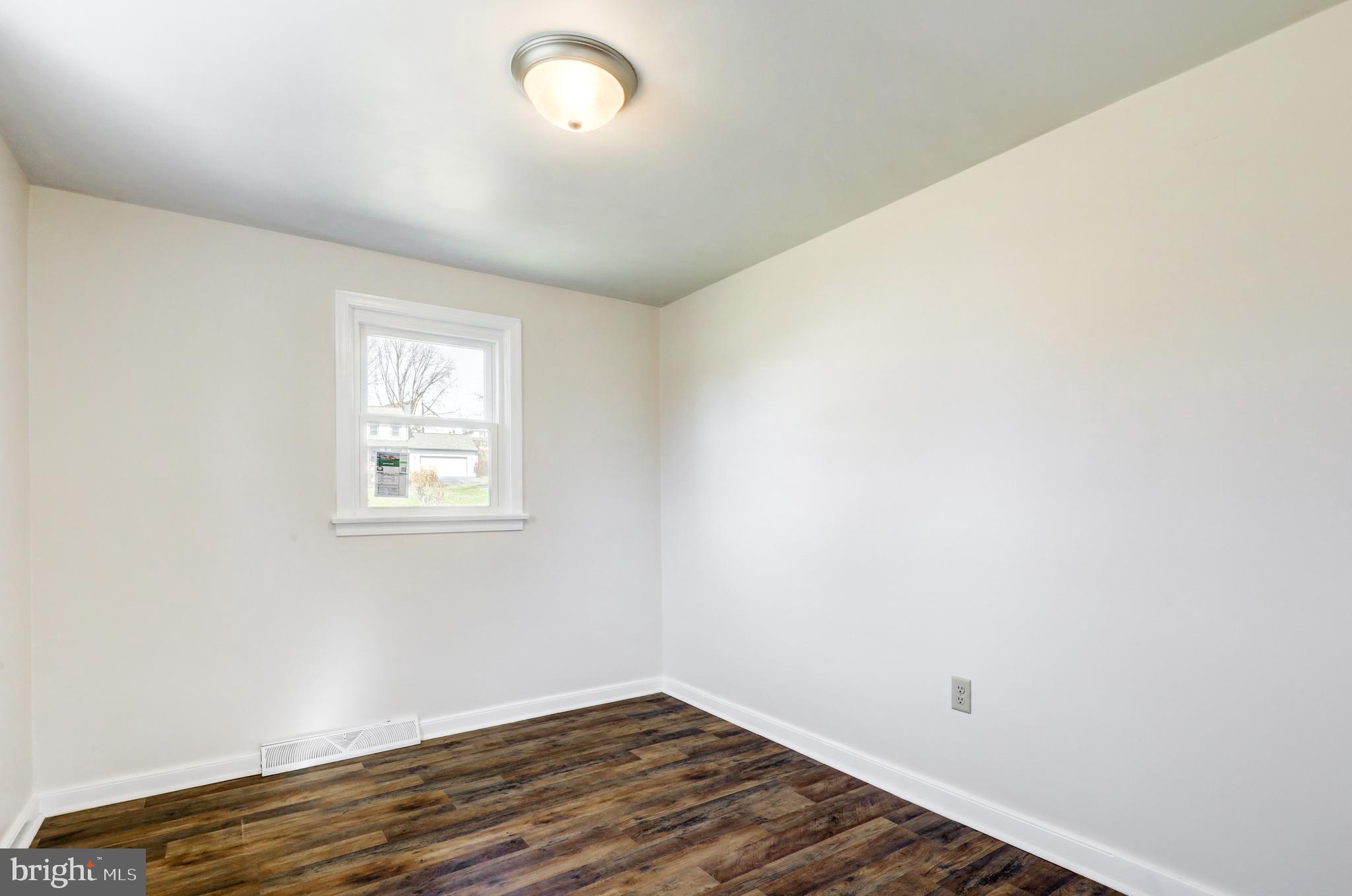 215 Akron Road Ephrata, PA 17522 - Photo 7 of 24 an empty room with wooden floor and windows