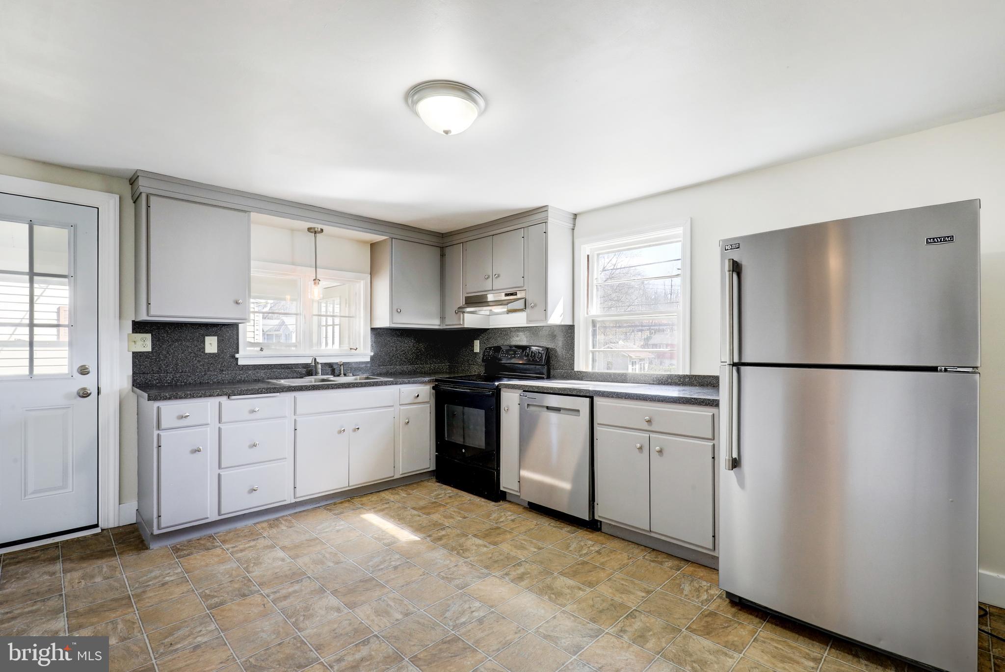 215 Akron Road Ephrata, PA 17522 - Photo 8 of 24 a kitchen with granite countertop stainless steel appliances a refrigerator sink and cabinets