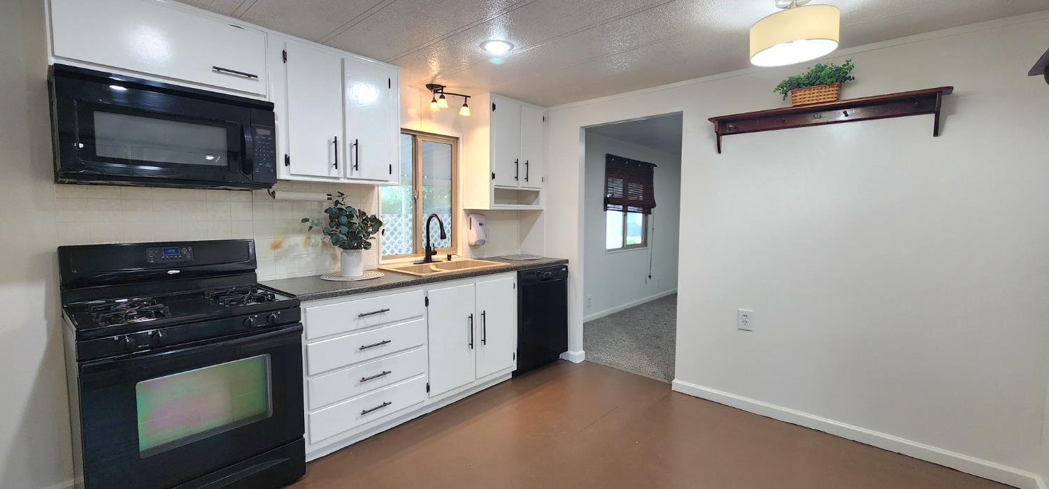 1300 West Olson Avenue, Unit 179 Reedley, CA 93654 - Photo 11 of 39 a kitchen with stainless steel appliances a stove microwave and cabinets