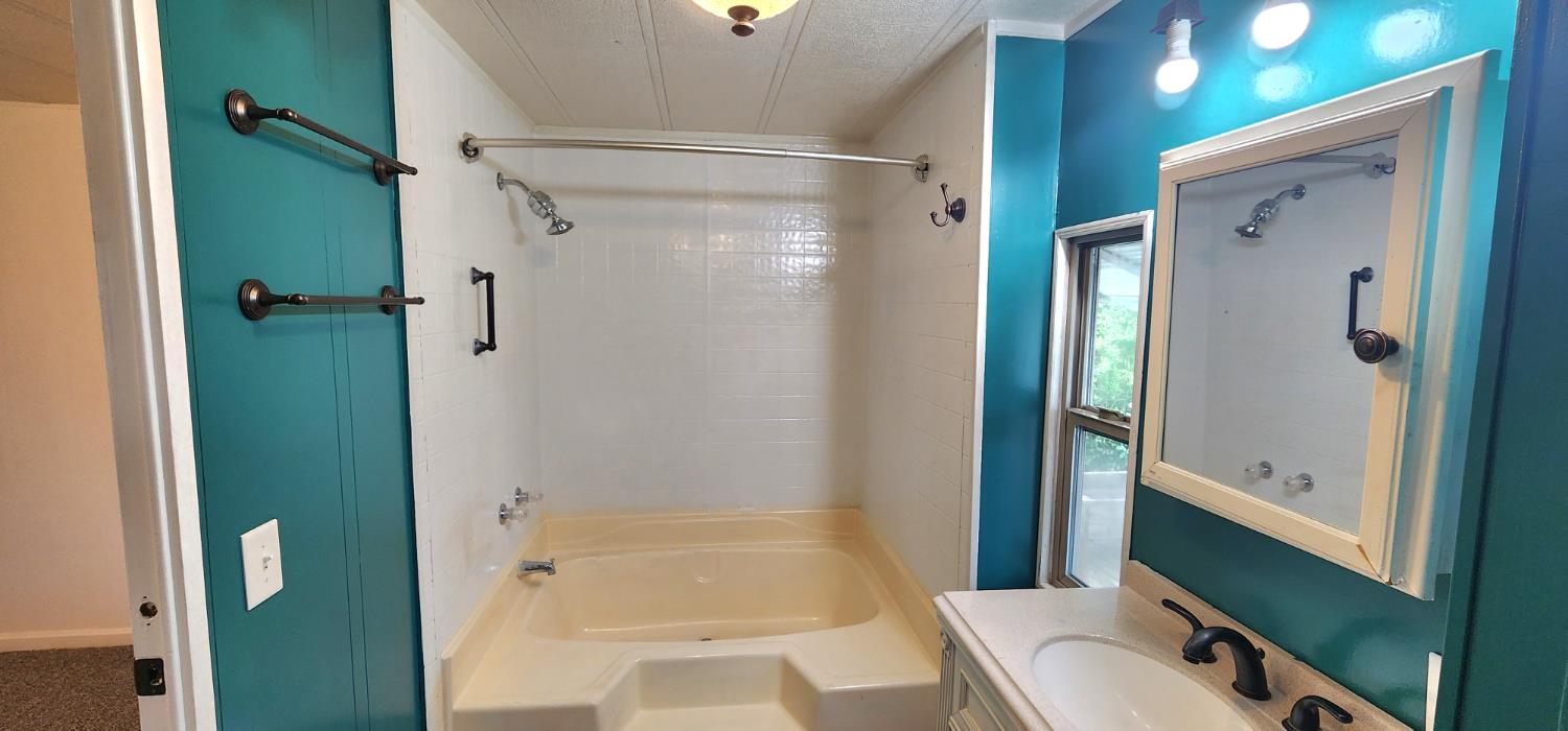 1300 West Olson Avenue, Unit 179 Reedley, CA 93654 - Photo 27 of 39 a bathroom with a tub and a shower