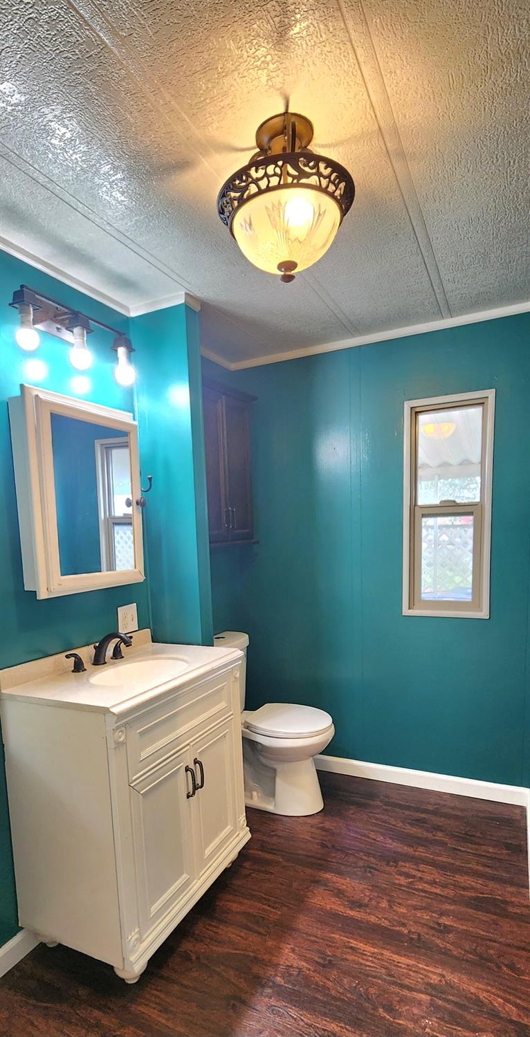 1300 West Olson Avenue, Unit 179 Reedley, CA 93654 - Photo 28 of 39 a bathroom with a toilet sink and mirror