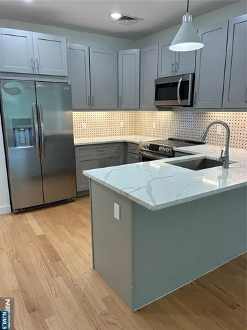a kitchen with granite countertop a sink a counter top space and cabinets