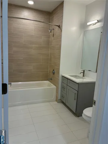 a bathroom with a bathtub a sink a toilet and a mirror