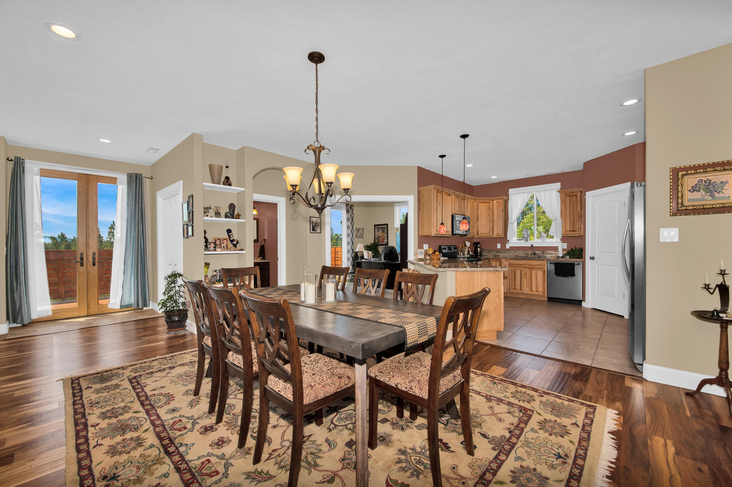 19112 Pumice Butte Road Bend, OR 97702 - Photo 14 of 36 a view of a dining room and livingroom with furniture wooden floor a chandelier